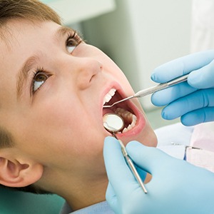 A young boy having his teeth checked before receiving dental sealants