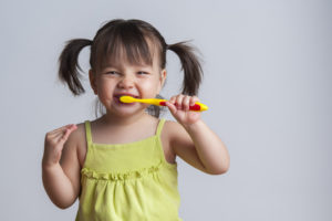 Small girl brushing her teeth. 