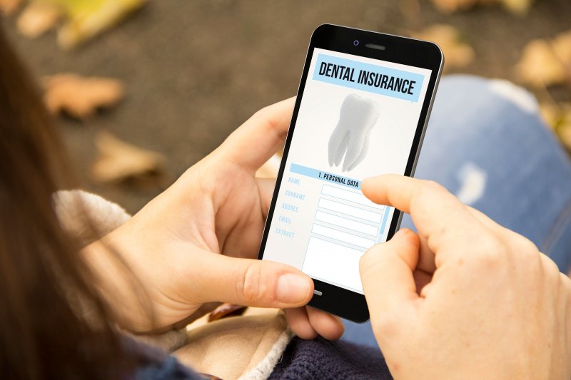 Woman looking at dental insurance form on her phone